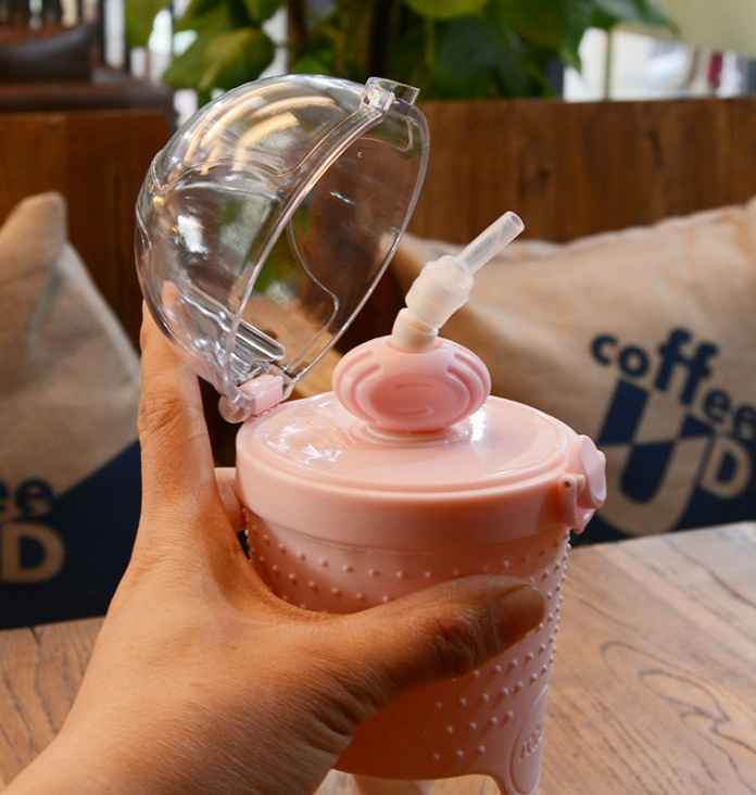Pink 500ml kids water bottle with straw on table